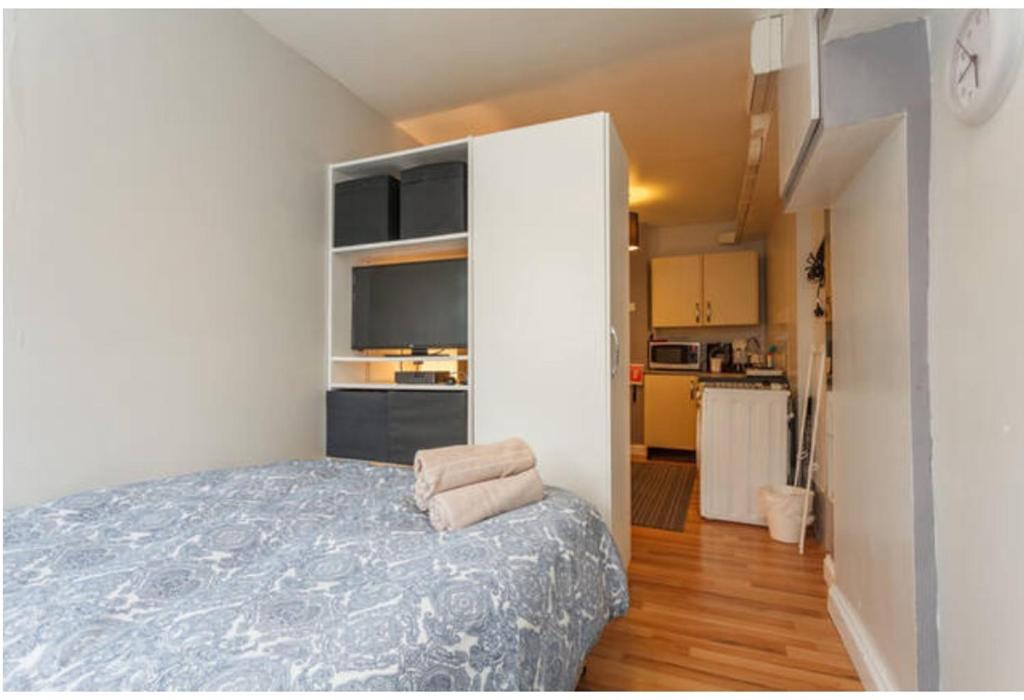 サウサンプトンにあるShirley Apartments, Cozy Studio, Self Check in, 10 min Drive to City Centre, Walking to Redbridge Train Stationの小さなベッドルーム(ベッド1台付)、キッチンが備わります。