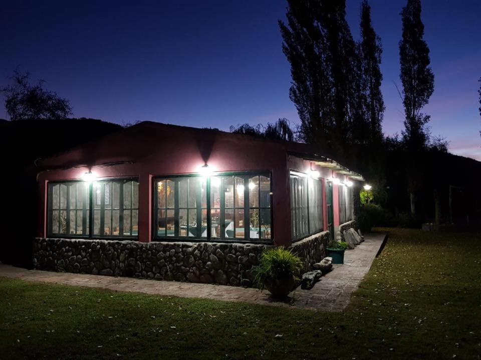 uma casa iluminada à noite com luzes em Finca La Media Luna em San Agustín de Valle Fértil