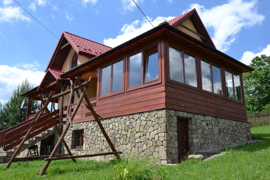 a small house with windows on top of a hill at Apartamenty Kasina in Kasina Wielka