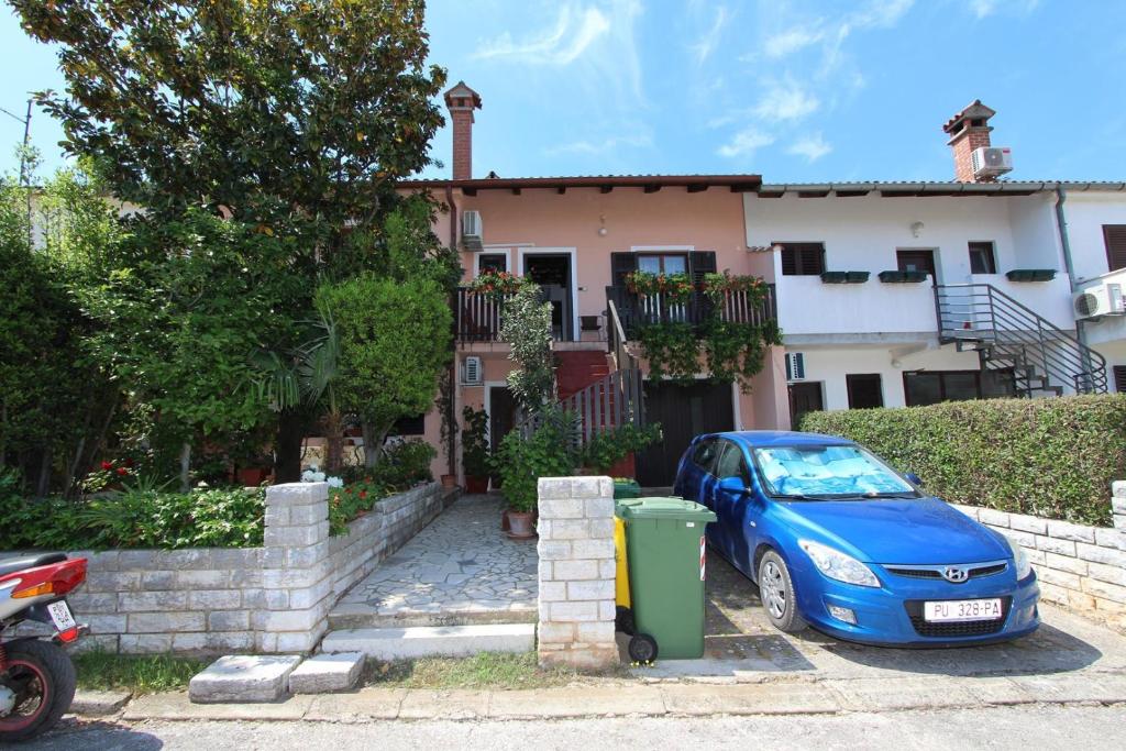 a blue car parked in front of a house at Apartments Sebal in Rovinj
