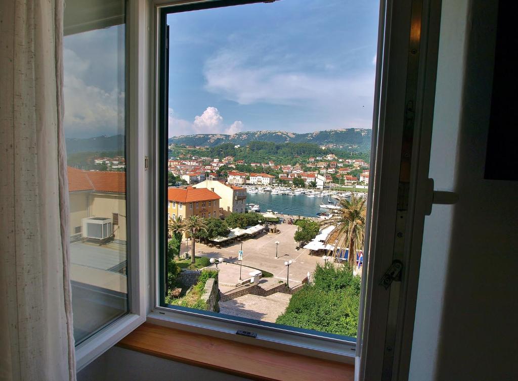 una finestra con vista su una città e una cassa d'acqua di Rooms and Studio Old Town a Rab