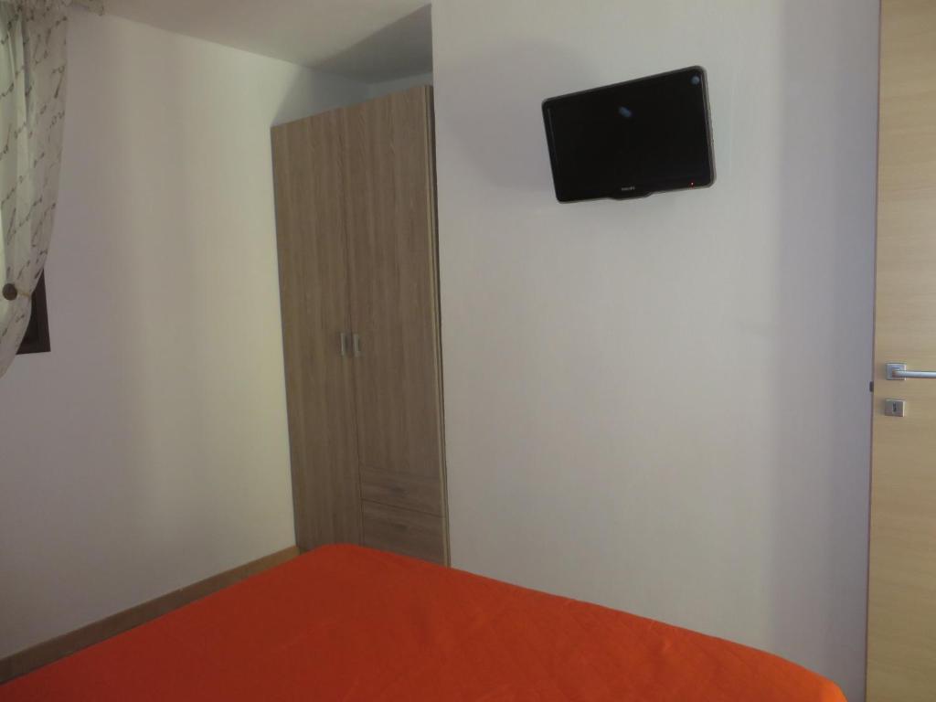 - une chambre avec un lit et une télévision murale à écran plat dans l'établissement La Casuzza di Lara, à Sciacca