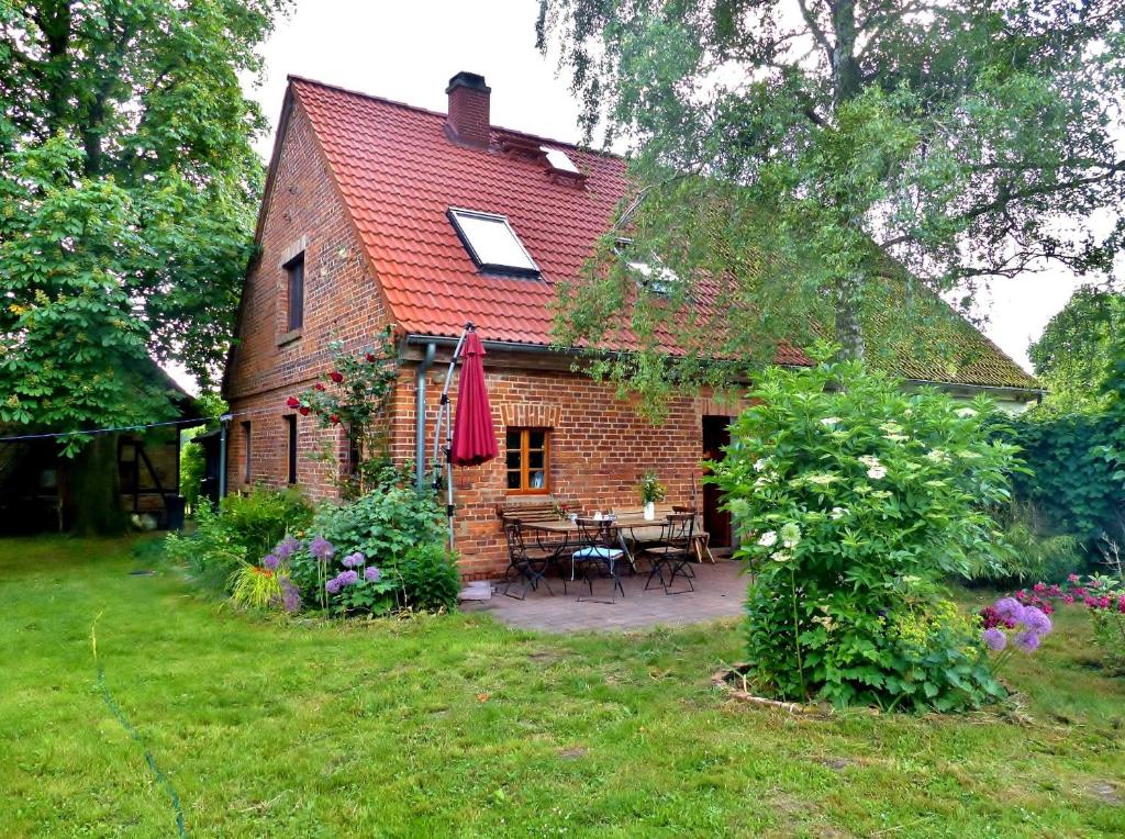 a brick house with a table and chairs in a yard at Ferienhaus Christoph Seeger in Bugewitz