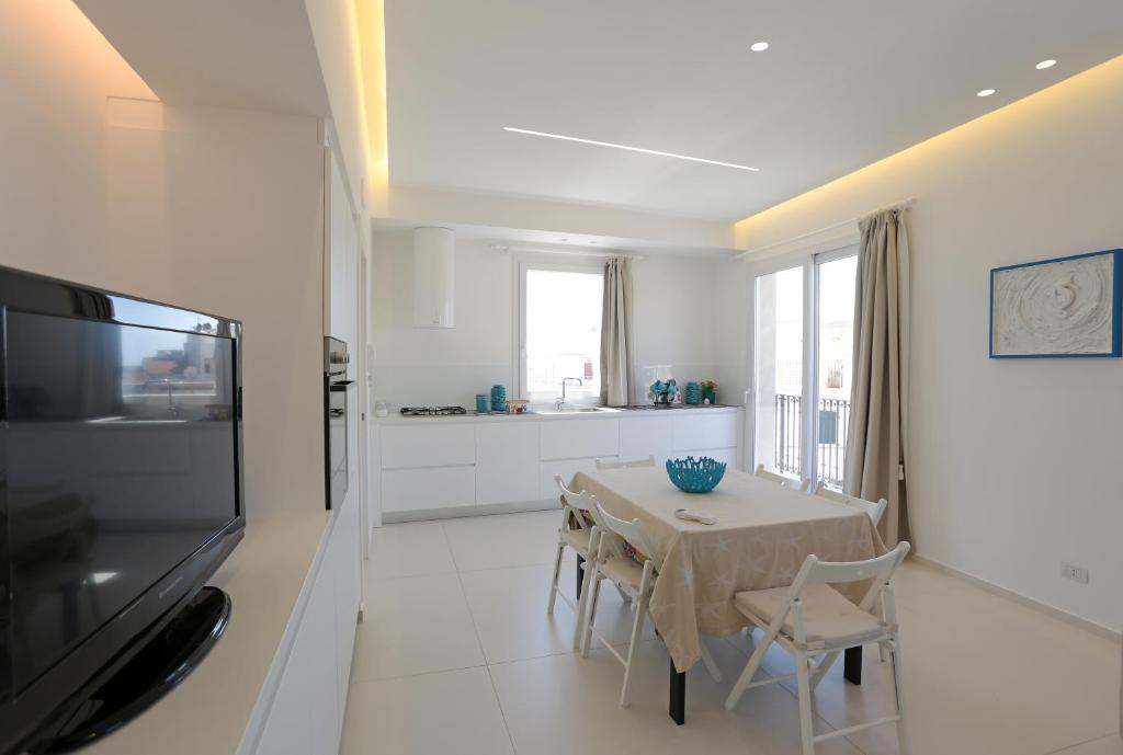 a kitchen and dining room with a table and a television at Mediterranean View in Marina di Ragusa