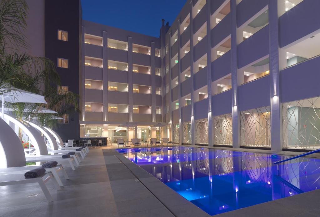 a hotel with a swimming pool at night at Melrose Rethymno by Mage Hotels in Rethymno