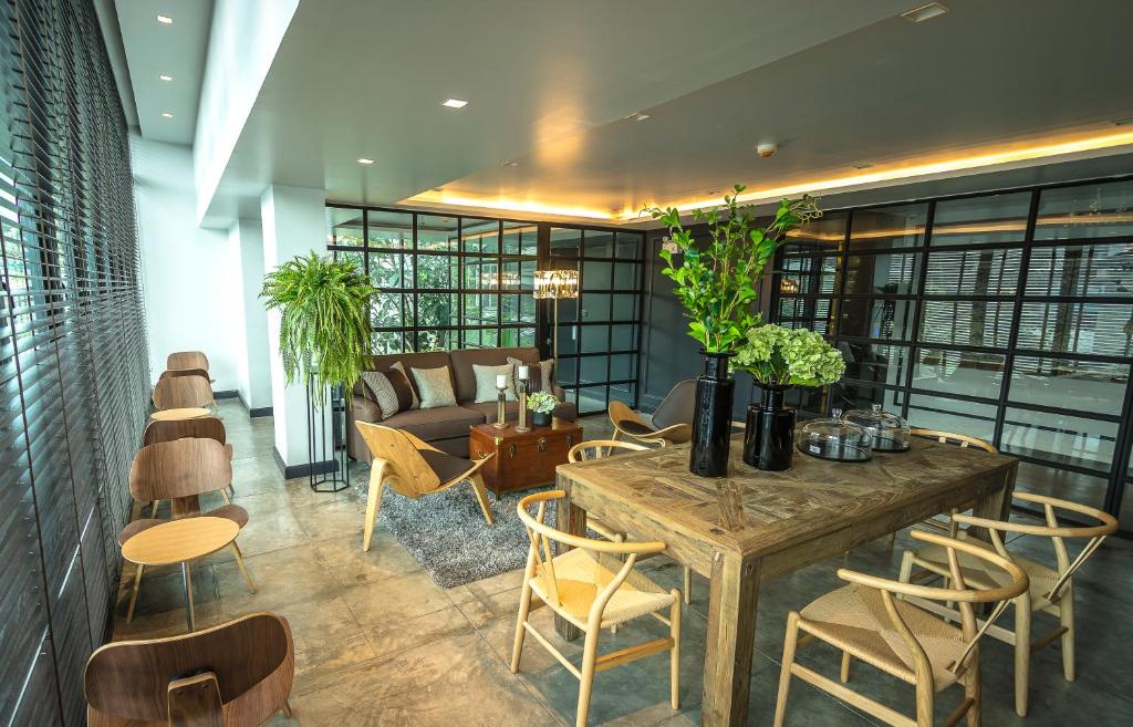 A bright shared lounge combines a dining table, sofa seating and a wall of windows.