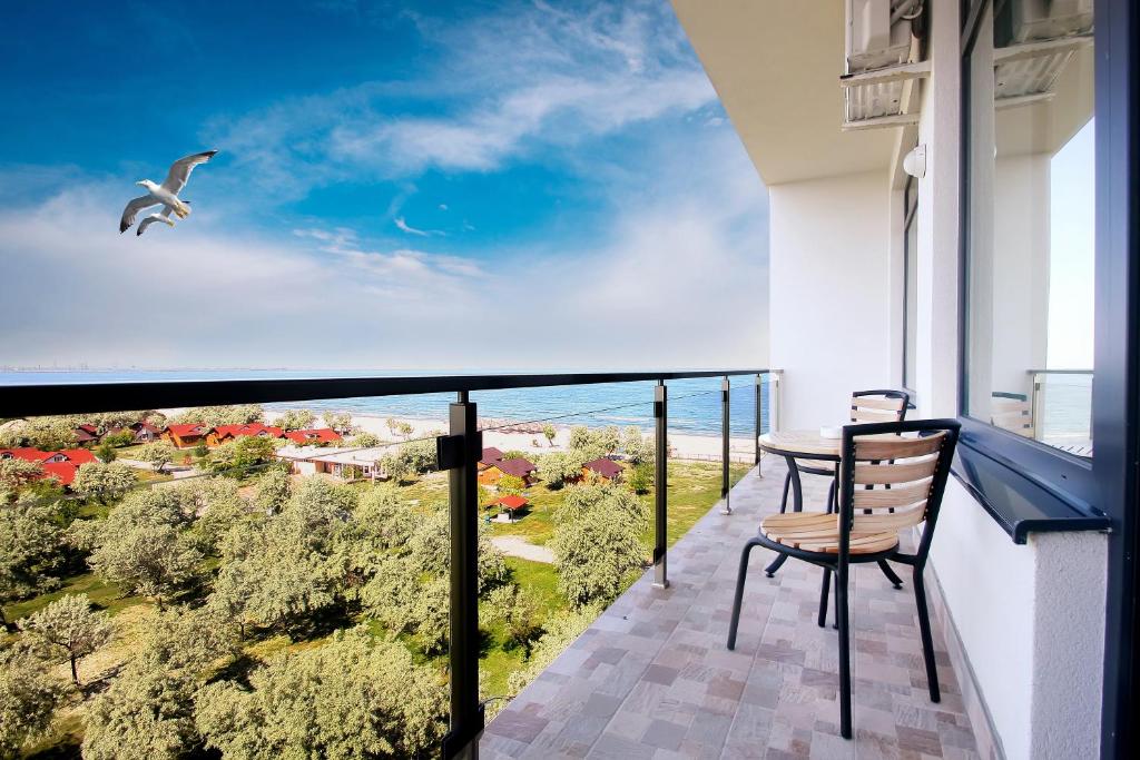 a balcony with a table and a bird flying in the sky at Lotus 7 Silver in Mamaia