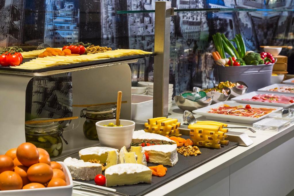 a buffet with many different types of cheese and vegetables at Melia Paris La Defense in Courbevoie