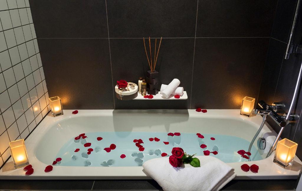 a bathroom with a bath tub with red roses on it at Melia Paris La Defense in Courbevoie