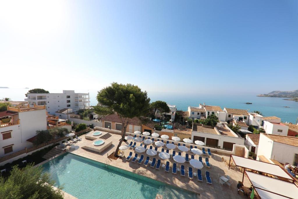 a view of a swimming pool with chairs and umbrellas at Hotel Clumba in Cala Ratjada