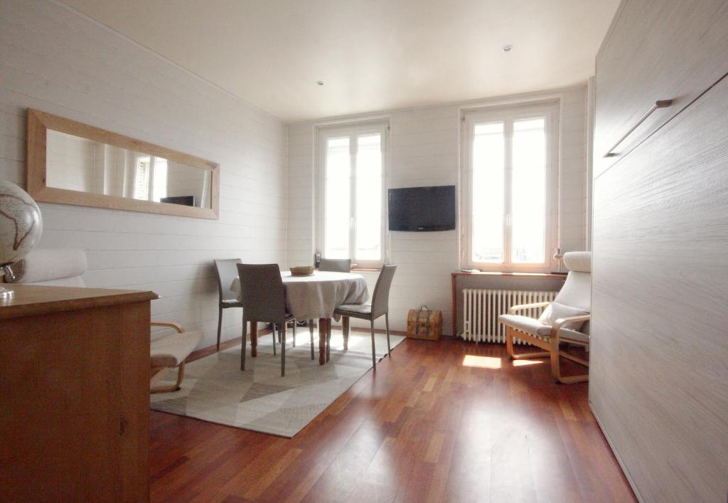 a dining room with a table and chairs and windows at Le quai Sud in Fécamp