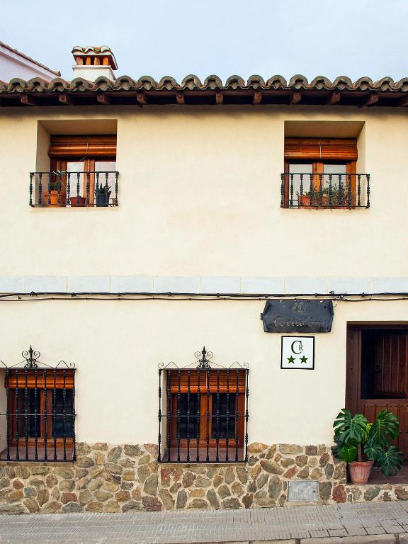 un edificio bianco con tre finestre e una porta di Casa rural El Corralón a Hinojal