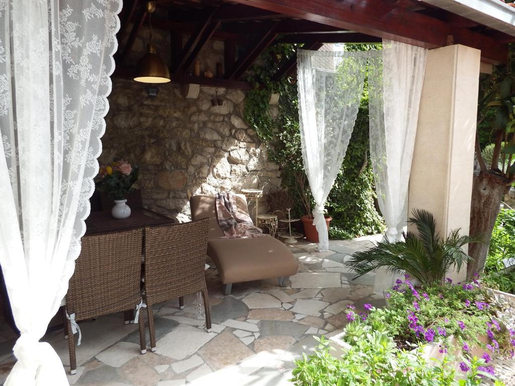 d'une terrasse avec une table et des chaises ainsi qu'un mur en pierre. dans l'établissement Apartment Julia, à Split