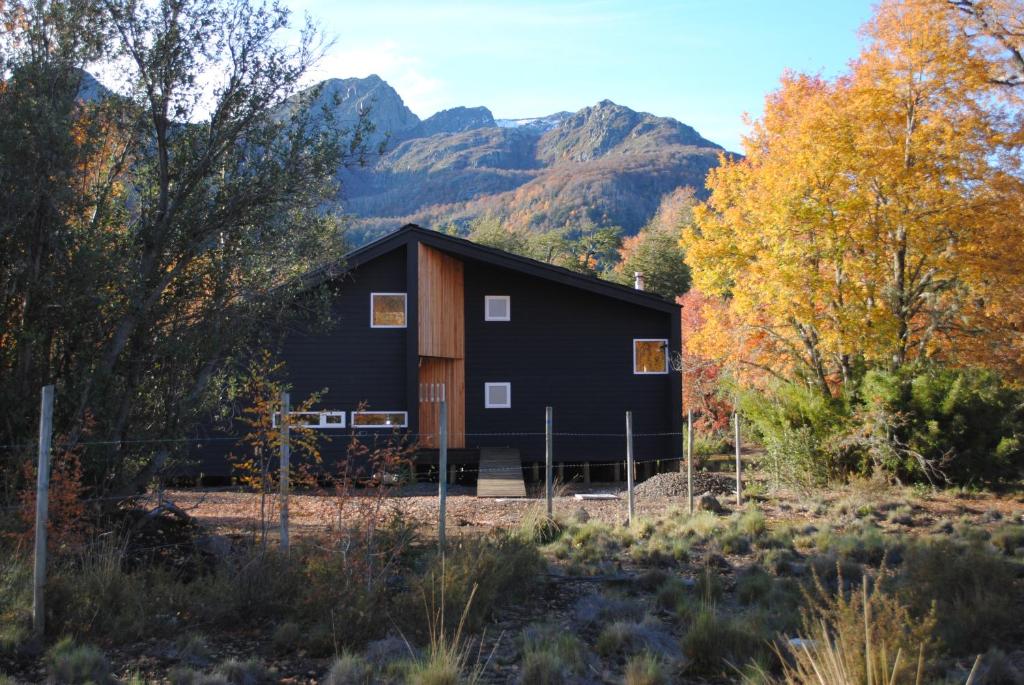 a black barn with mountains in the background at Casa Negra Nevados de Chillan in Las Trancas