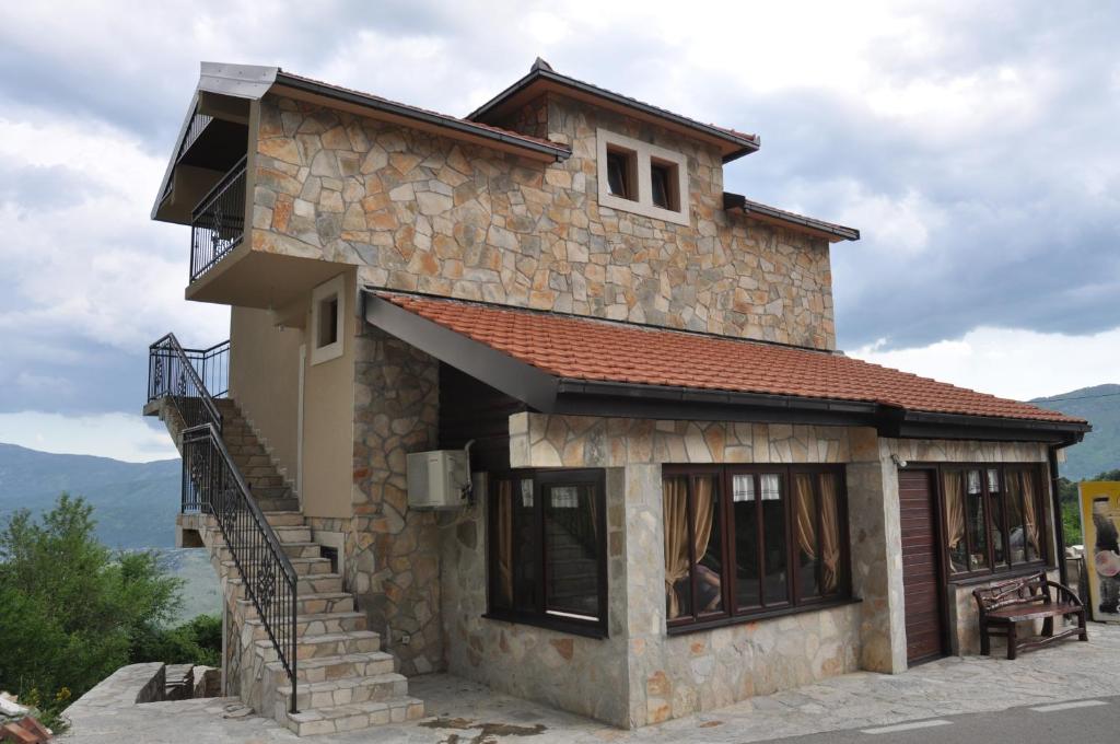 a stone house with a staircase in front of it at Ostroške grede in Nikšić