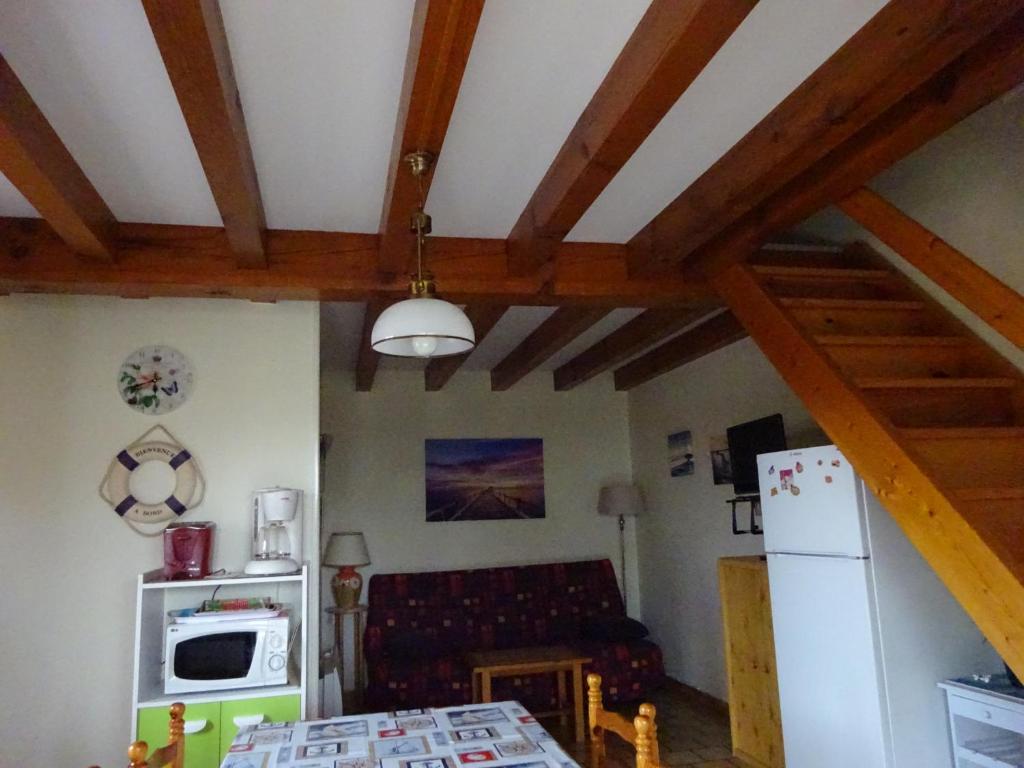 a kitchen with wooden ceilings and a room with a refrigerator at Les Lagagnons in Biscarrosse
