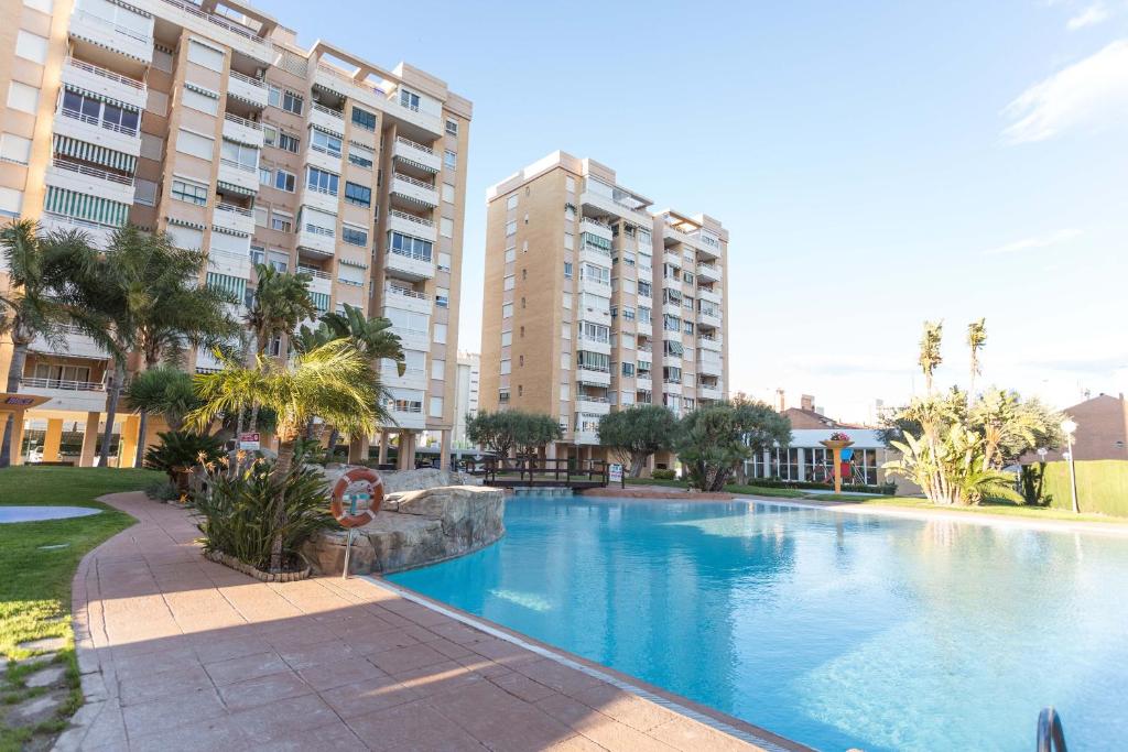 une grande piscine en face de certains bâtiments dans l'établissement Nations Apartment with pool, à Alicante