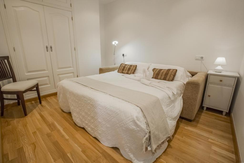 1 dormitorio con 1 cama blanca grande y 1 silla en Skyline Penthouse en Alicante