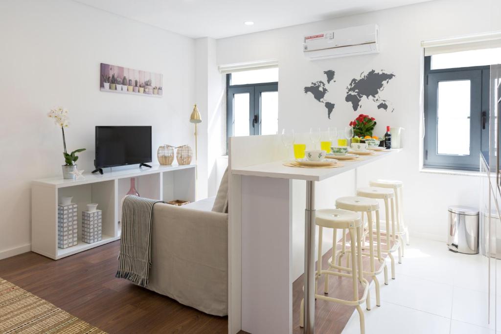 a white living room with a bar with stools at APOSENTUS - Your home at Pinheiro's Residence in Porto