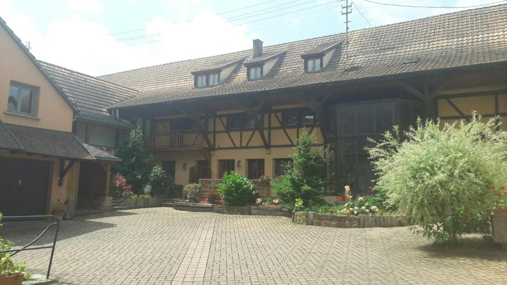 uma casa grande com uma entrada de tijolos em frente em Chez Frédéric et Alexandre em Bennwihr