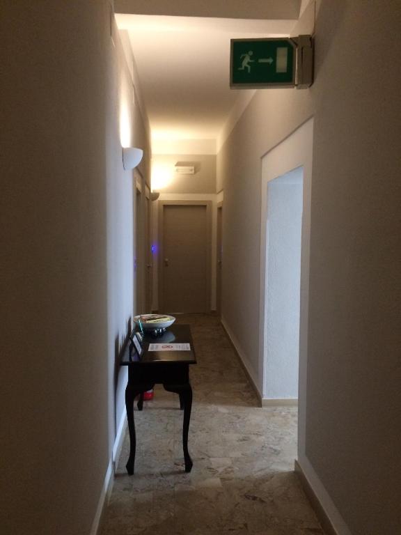 a hallway with a table and a clock on a wall at Residence Ducale in Rodi Garganico