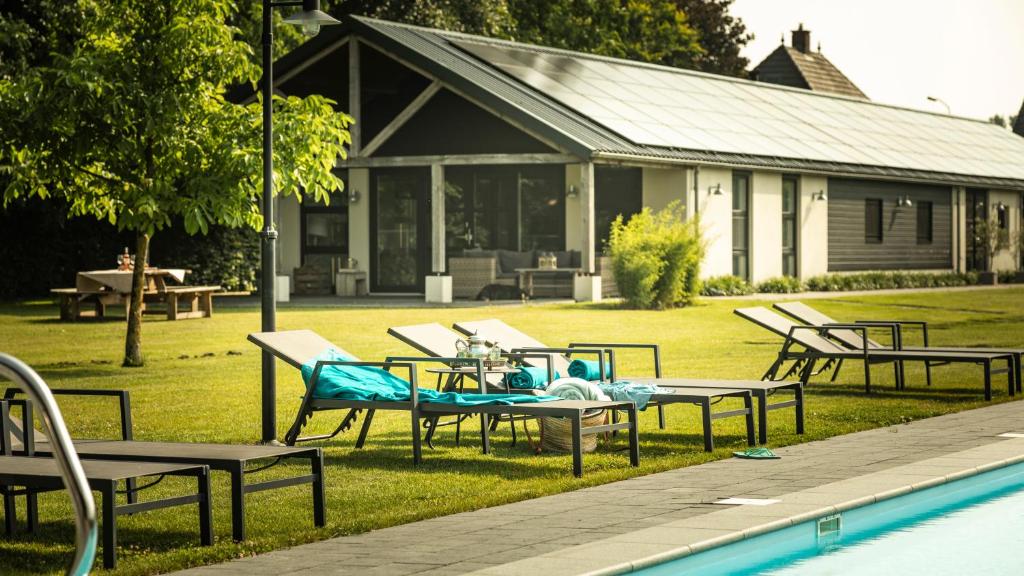 un grupo de mesas y sillas junto a una piscina en Liefkeshoek en Cuijk