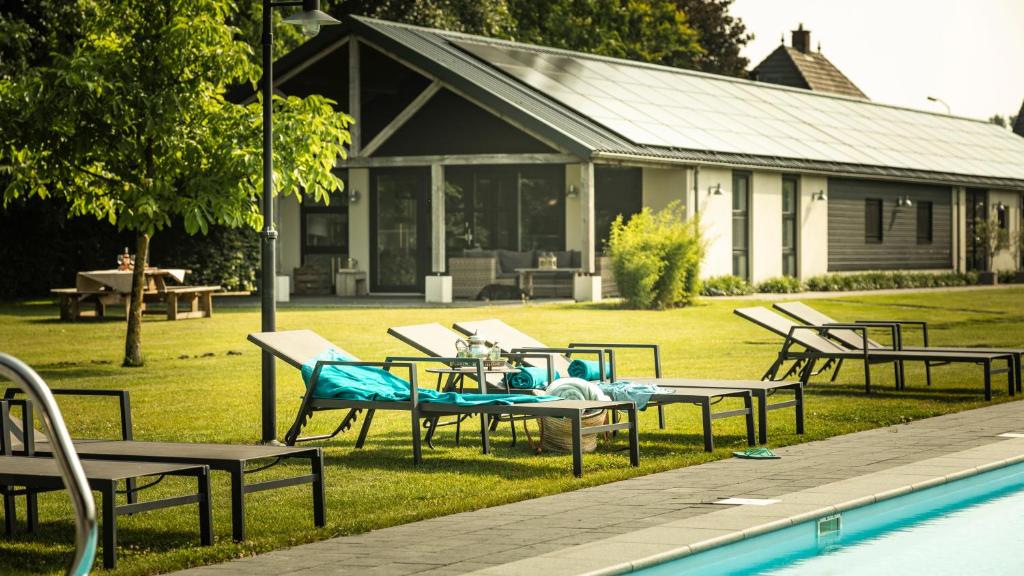 - un groupe de tables et de chaises à côté d'une piscine dans l'établissement Liefkeshoek, à Cuijk