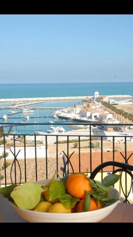 a bowl of fruit on a table with a view of the beach at Residence Ducale in Rodi Garganico