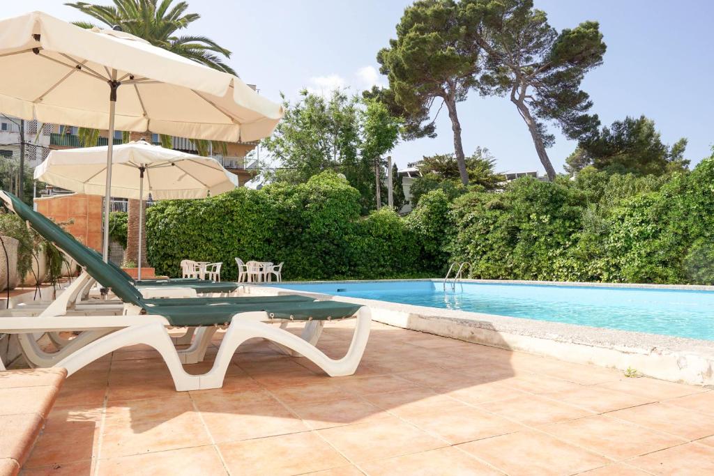 a pool with a table and an umbrella next to it at Houm Nets - Adults Only in Playa de Palma