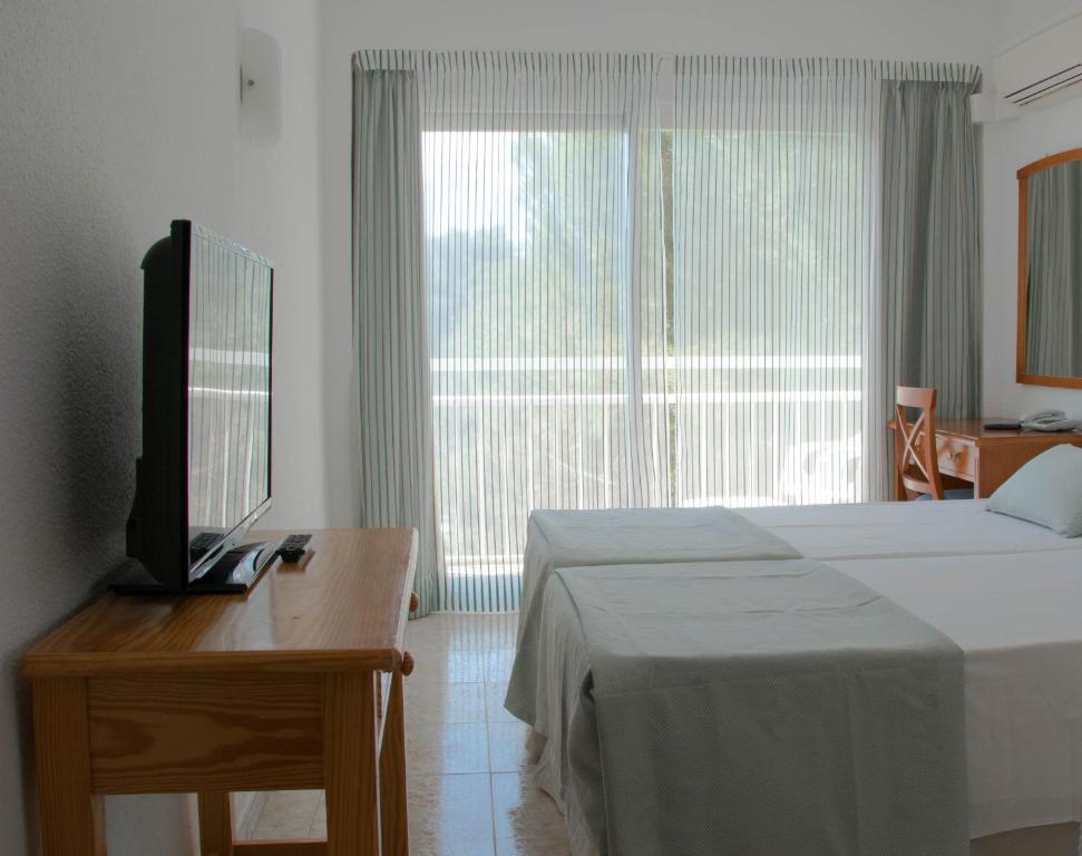 a bedroom with a bed and a television at Houm Nets - Adults Only in Playa de Palma