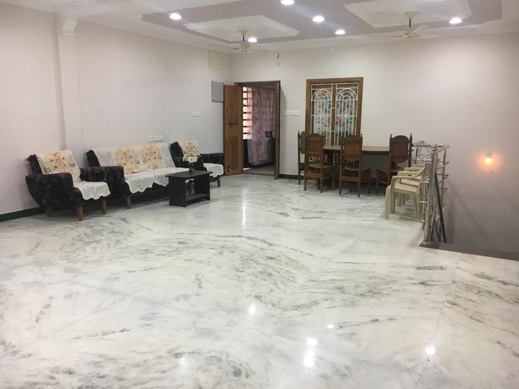 ein großes Wohnzimmer mit Marmorboden in der Unterkunft Pleasant Stay in Tiruchchirāppalli