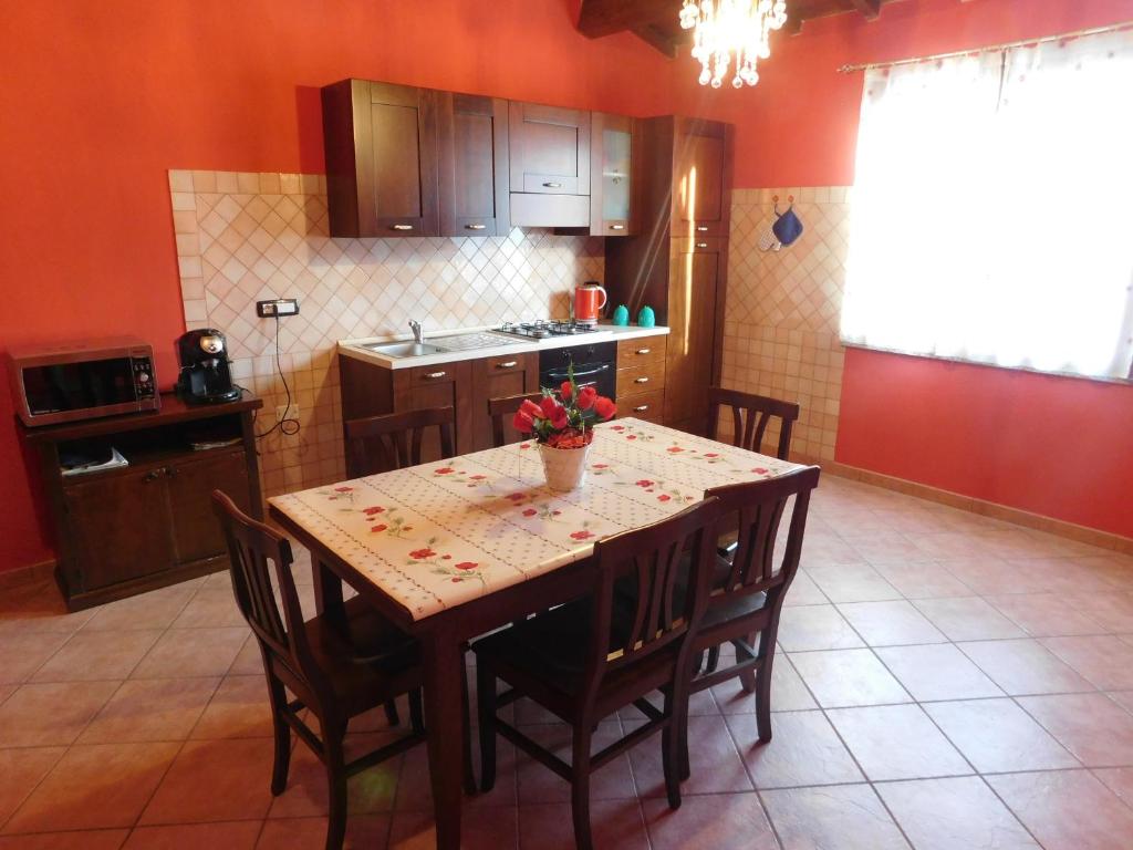 a kitchen with a wooden table with chairs and a tableasteryasteryasteryasteryastery at Casa Cristina in Milis