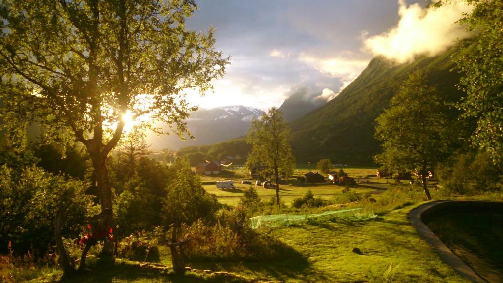 una vista de un valle con una montaña en el fondo en Dalen Gaard camping og hytter, en Geiranger