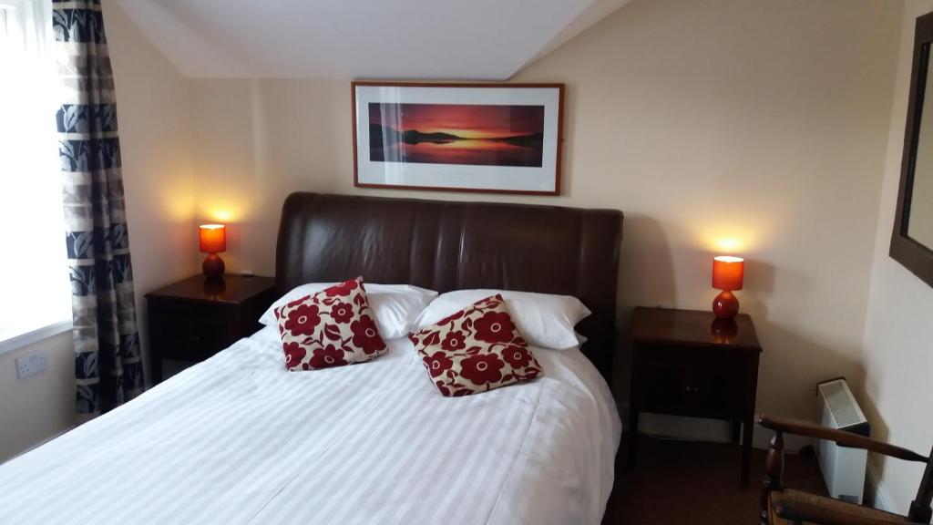 ブラックプールにあるdelamere holiday apartmentsのベッドルーム1室(赤い枕2つ付)