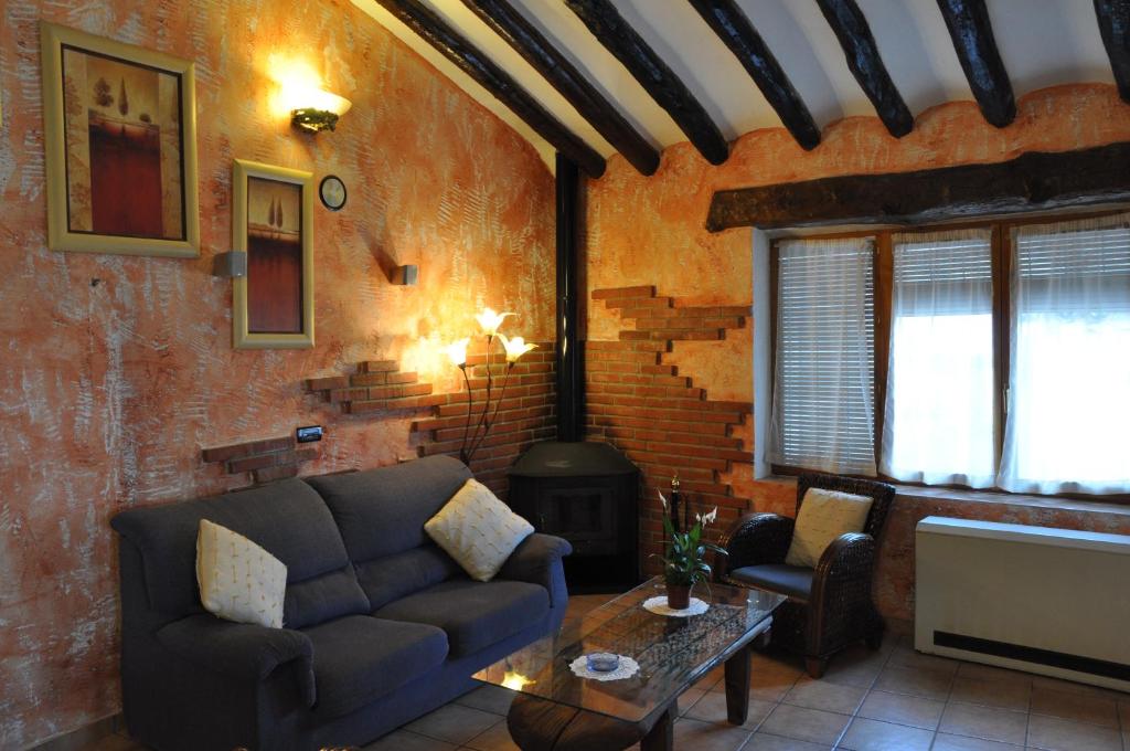 - un salon avec un canapé et un poêle à bois dans l'établissement Casa Rural El Pajar del Portalico, à Letur