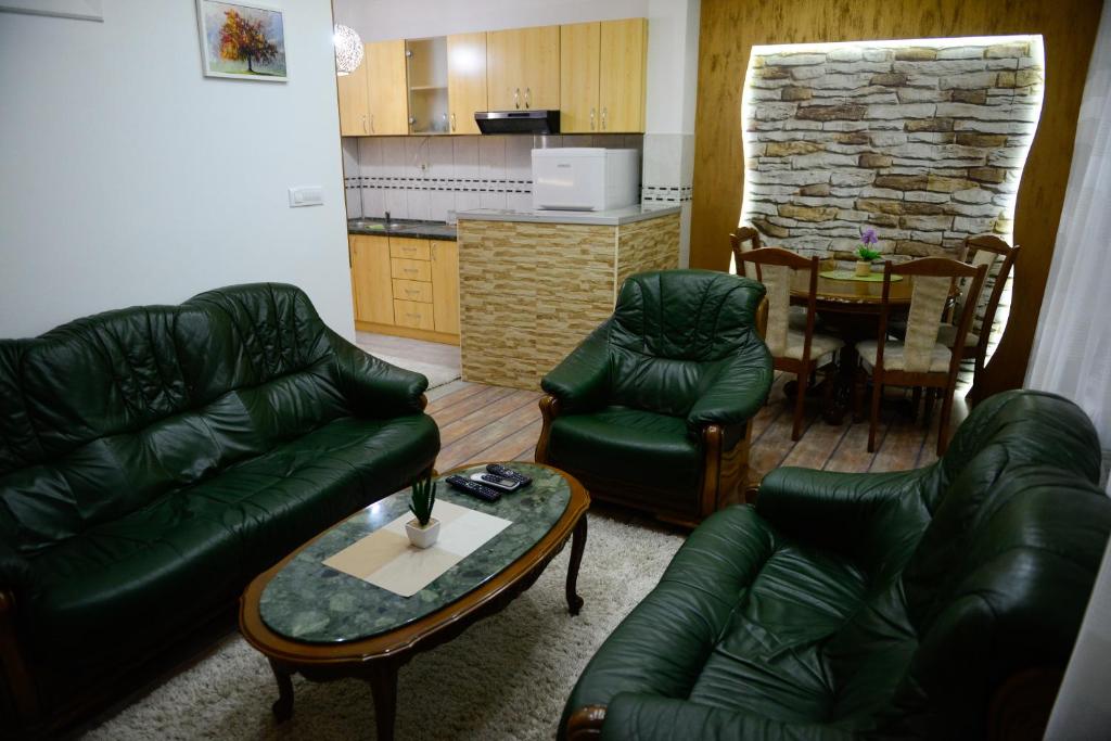 a living room with a couch and chairs and a table at Apartments MM in Nik&scaron;ić
