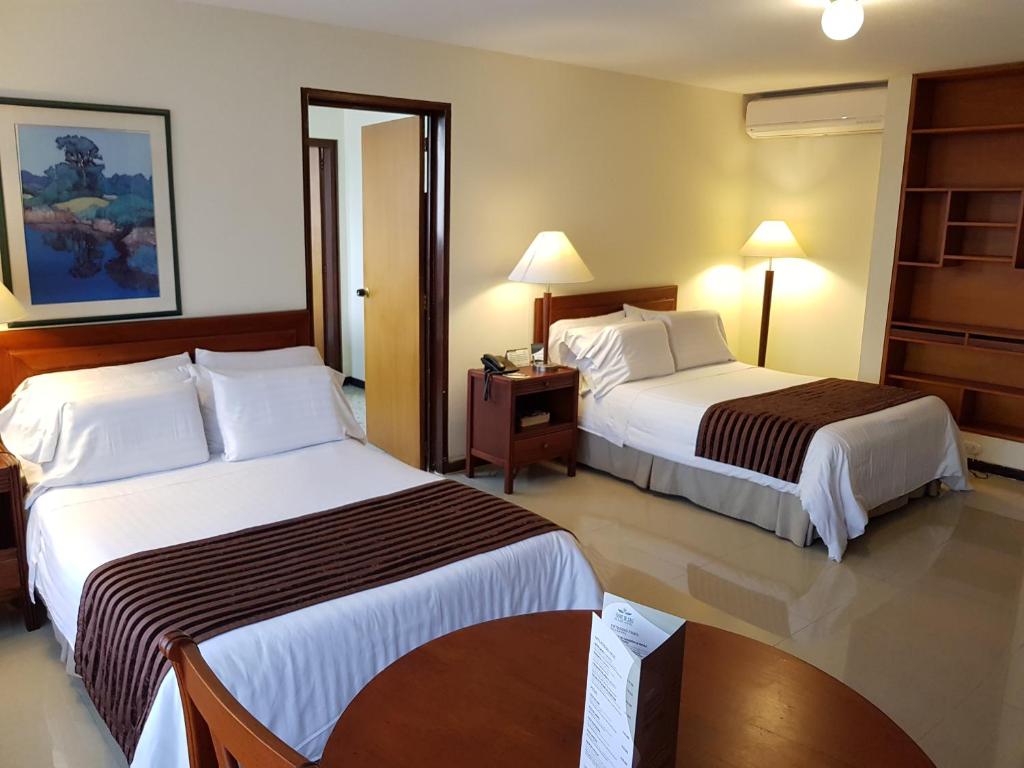Llit o llits en una habitació de Torre de Cali Plaza Hotel