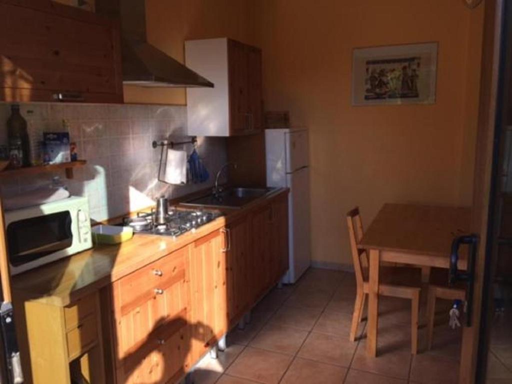 eine Küche mit einer Theke und einem Tisch mit einer Mikrowelle in der Unterkunft Appartamenti Le Cicale in Fertilia