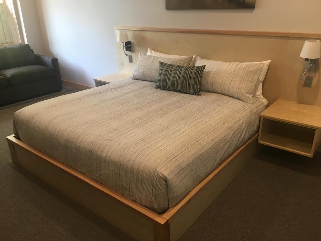 a large bed in a room with a chair and a couch at Harbour House Hotel in Ganges