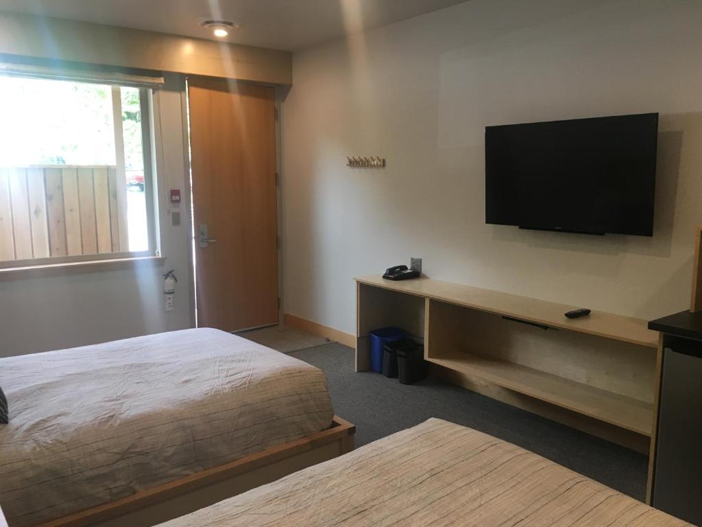 a hotel room with a bed and a flat screen tv at Harbour House Hotel in Ganges