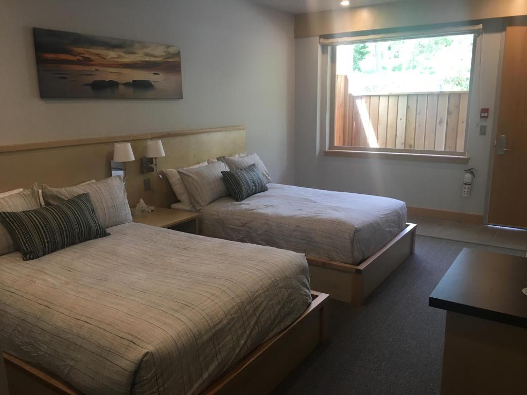 a hotel room with two beds and a window at Harbour House Hotel in Ganges
