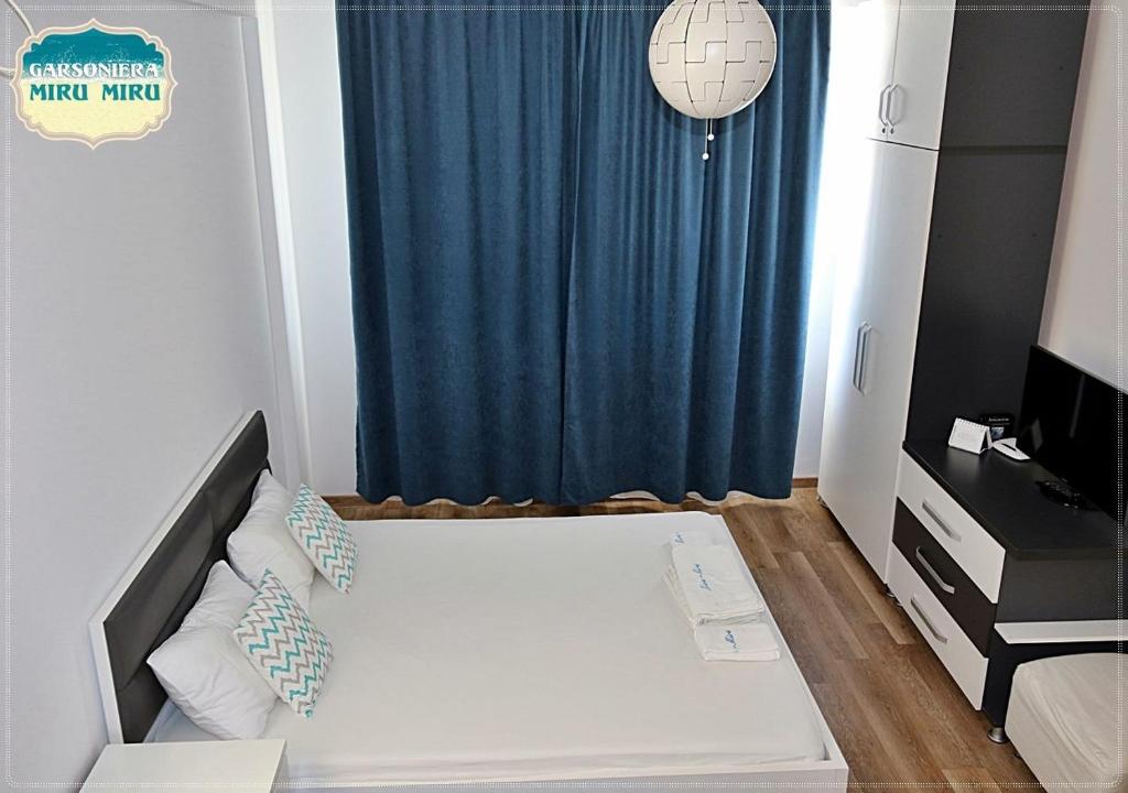 ママイア・ノルドにあるGarsoniera Miru Miruのベッドルーム1室(青いカーテン付きのベッド1台付)