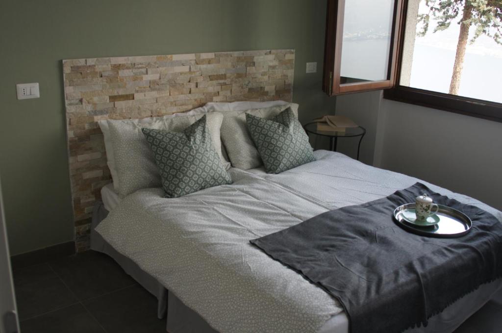 a bedroom with a large bed with a brick wall at casa dei nonni 2 in Tremosine Sul Garda