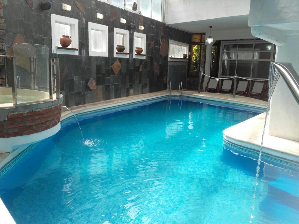 - une grande piscine d'eau bleue dans une chambre dans l'établissement Medamar Club, à Villa Gesell