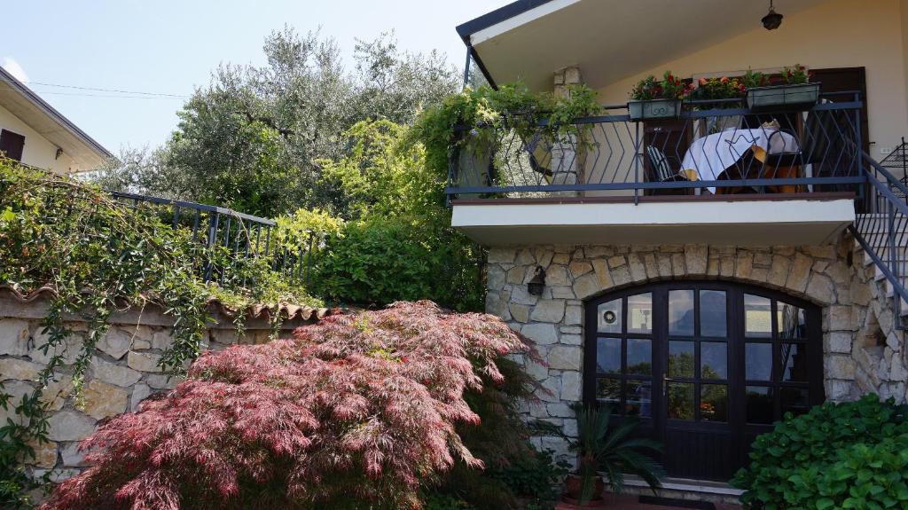a man standing on the balcony of a house at Bed and Breakfast Due Leoni in Torri del Benaco