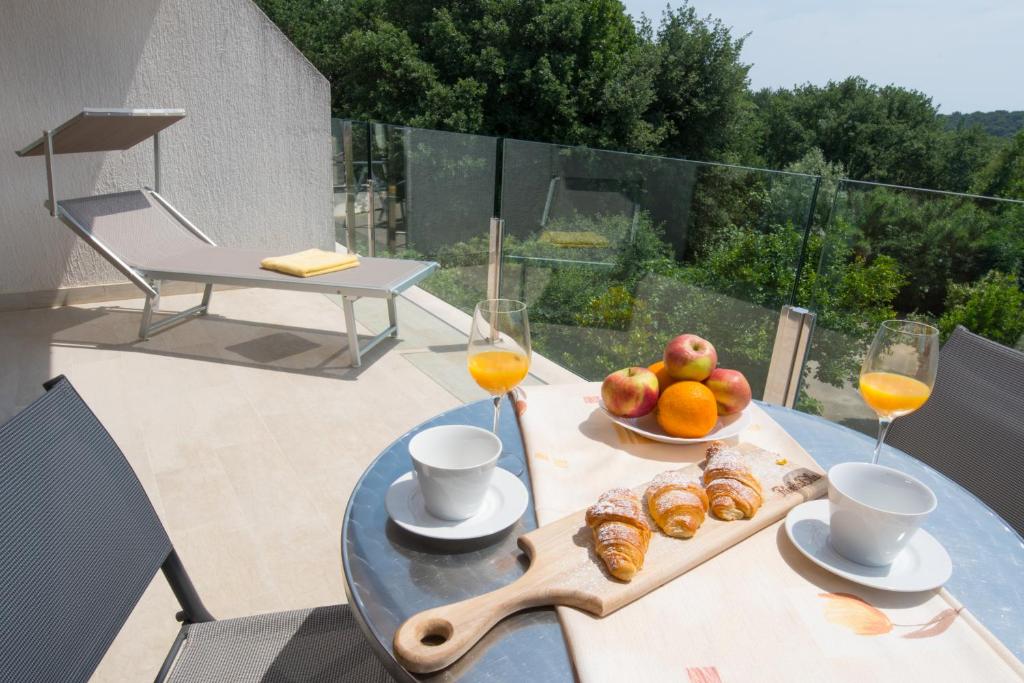 a table with a bowl of fruit and two glasses of orange juice at Apartmani MIRA in Premantura