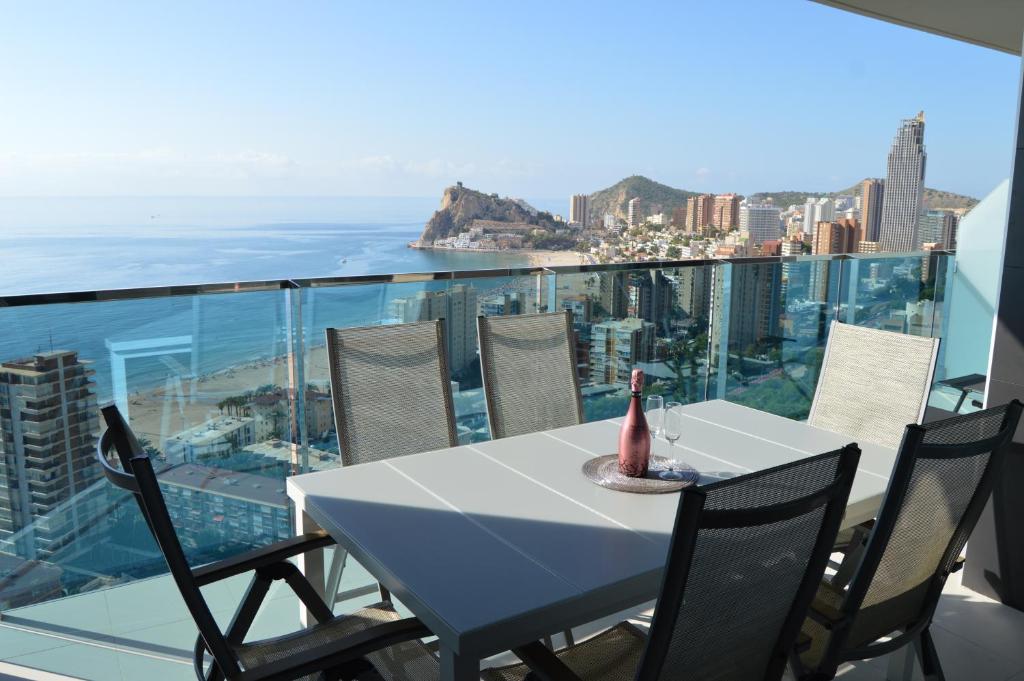 a table and chairs on a balcony with a view of the ocean at Sunset Drive Exclusive - Benidorm in Benidorm