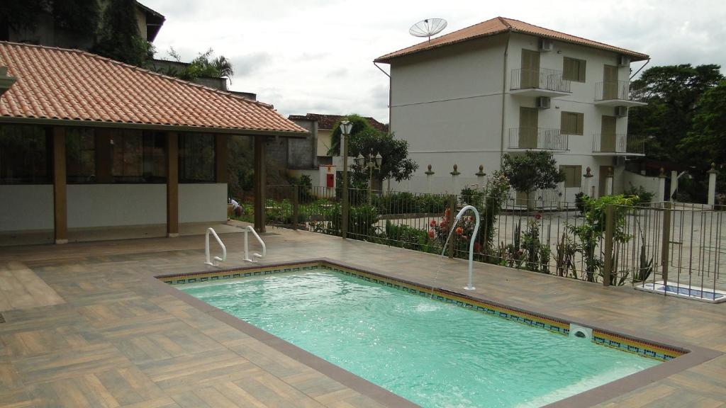 a swimming pool in front of a house at Residencial Mb in Conservatória