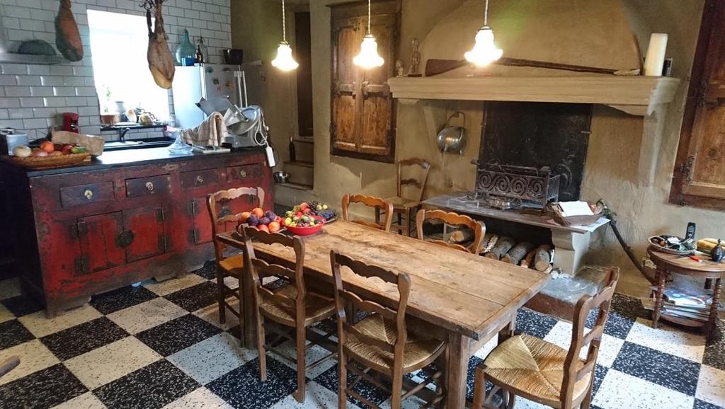 a kitchen with a wooden table with chairs and a stove at La belle endormie in Cabrerolles