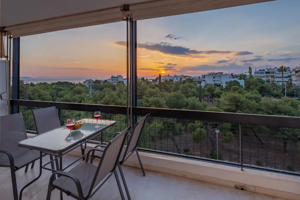 stół i krzesła na balkonie z widokiem w obiekcie Archer - Sea view apartment w Atenach